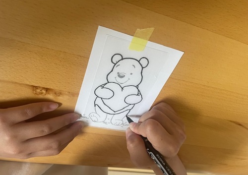 プラ板にイラストを描き写す様子